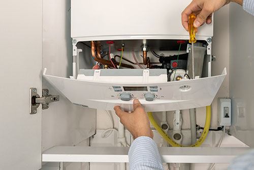 Heating technician repairing a residential boiler in Dublin