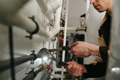 Technician inspecting commercial plumbing pipes in Dublin