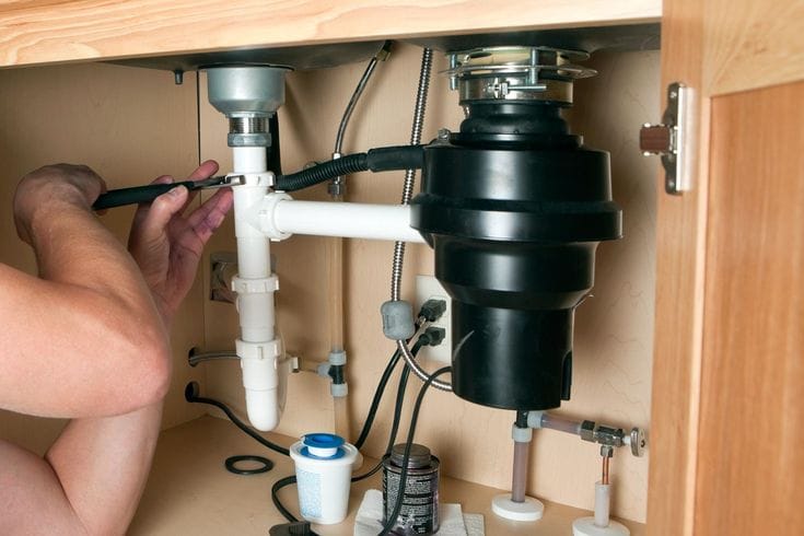 Plumber repairing a garbage disposal in Dublin