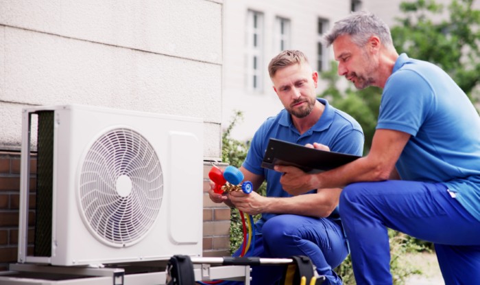 HVAC technicians installing an outdoor air conditioning unit in Dublin