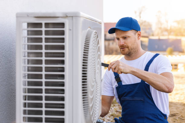 HVAC technician servicing an outdoor air conditioner in Dublin